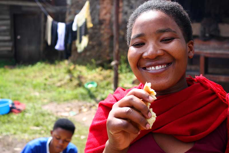smiling girl eating bread